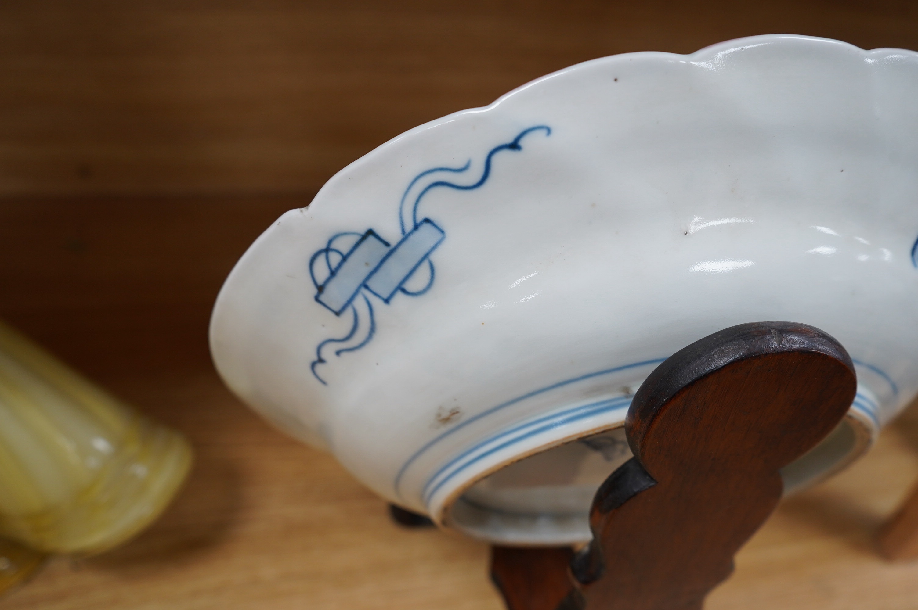 A Japanese Imari dish, circa 1900, on carved wooden stand, 31cm diameter. Condition - fine crack top right base of dish